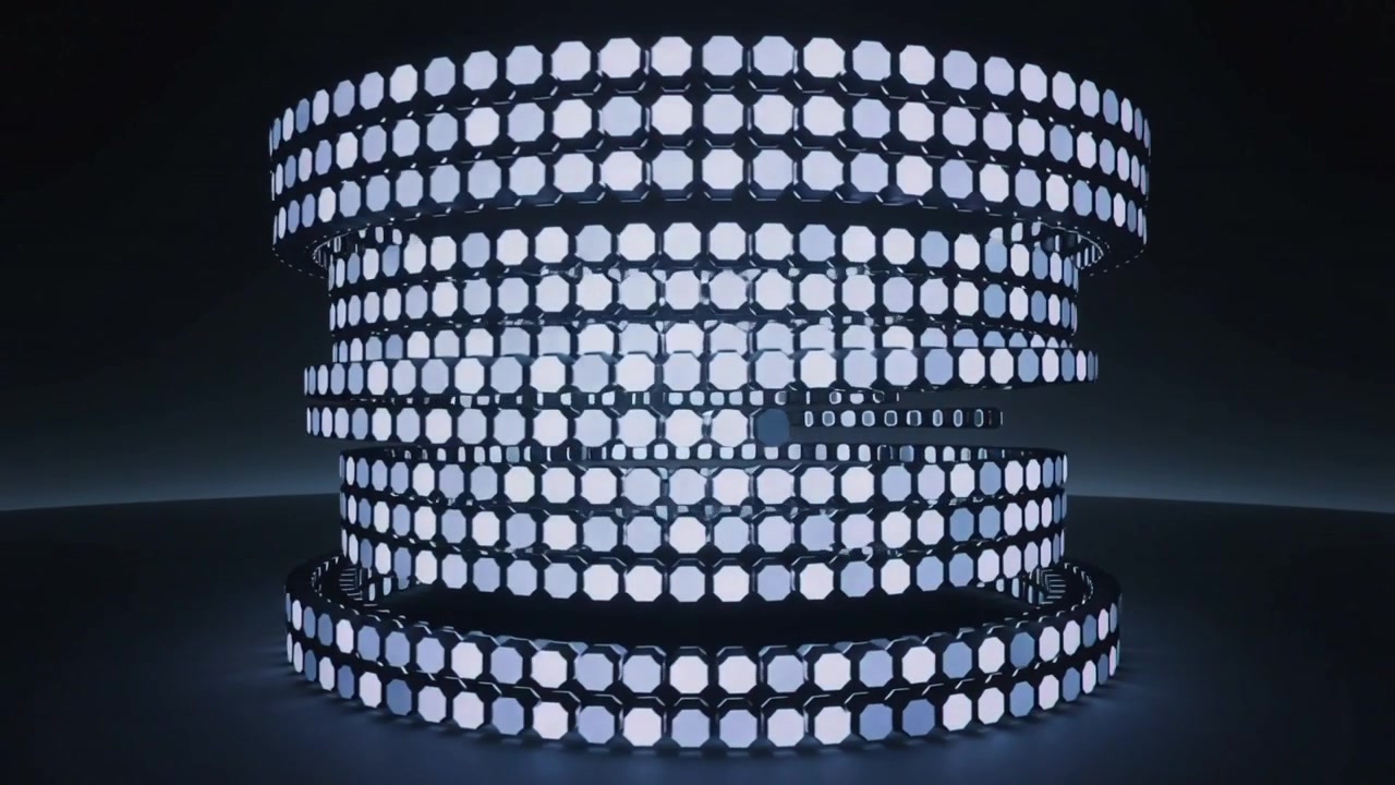 L'illuminazione si intensifica, una torre di anelli LED si sposta e apre varchi tra gli anelli centrali in studio, rivelando il nucleo.