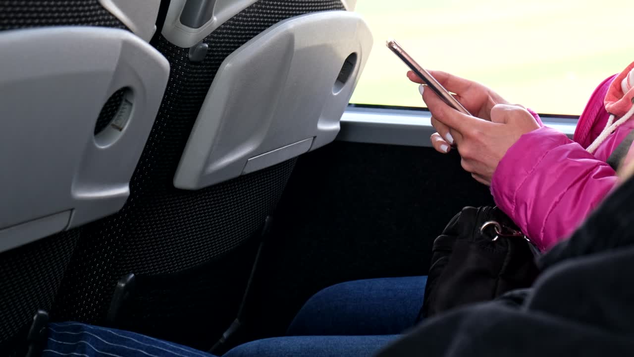 woman surfing internet on the phone coach bus travel