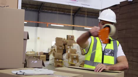 trabajador de almacén sellando cajas de cartón para el envío