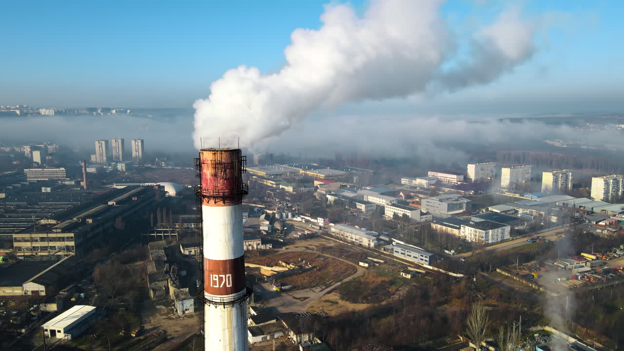 Aerial drone view of Chisinau. Thermal station with smoke coming out of the tube. Buildings, roads. Fog in the air. Moldova