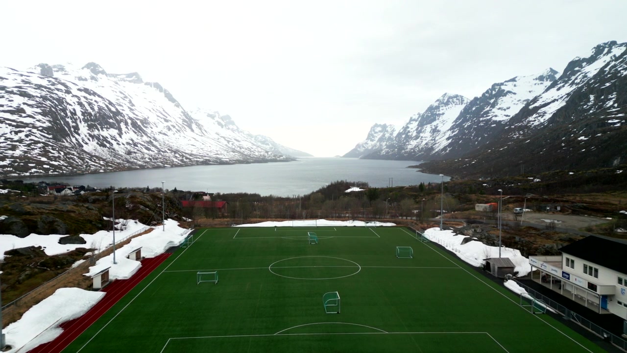 Fußballplatz in einem malerischen, schneebedeckten Fjord, Ersfjordbotn. Luftaufnahme.