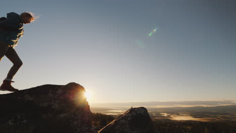 active woman reaches the top of the mountain admires the magnificent scenery of norway