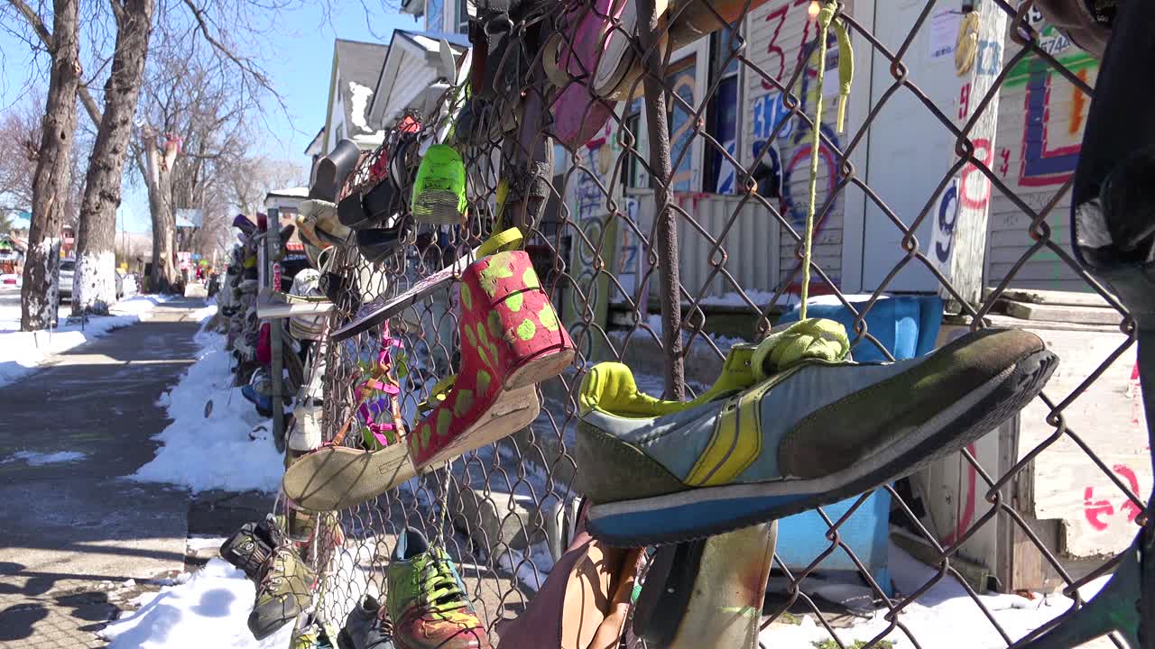 los zapatos cuelgan de una valla en una sección del gueto del centro de detroit, michigan 1