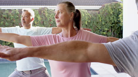 practicing yoga, senior friends stretching arms in outdoor group session