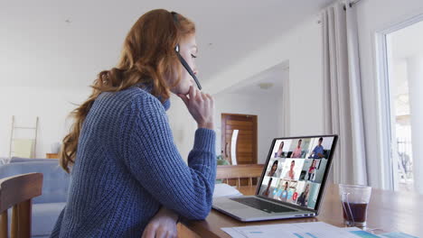 mujer caucásica usando portátil y auriculares de teléfono en videollamada con colegas
