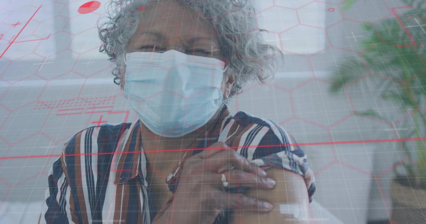 Senior woman holding upper arm after vaccine feeling bandage while red grid overlay moving over her