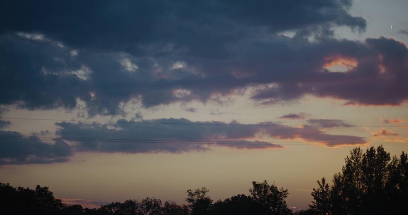 Time Lapse of Dramatic Sunset Clouds Moving Over Trees