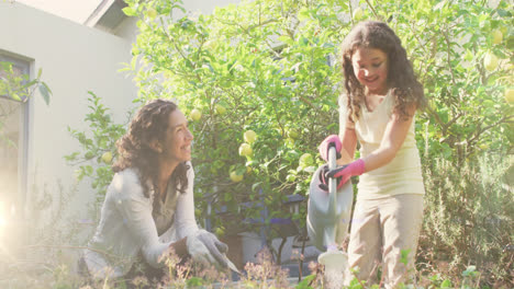 video of lights over happy biracial woman and girl watering garden