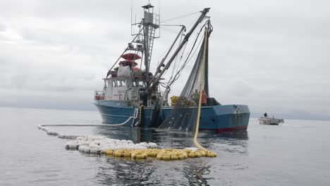 Fishing-Boat-Pulling-Out-Net-From-Sea,-Slow-Motion