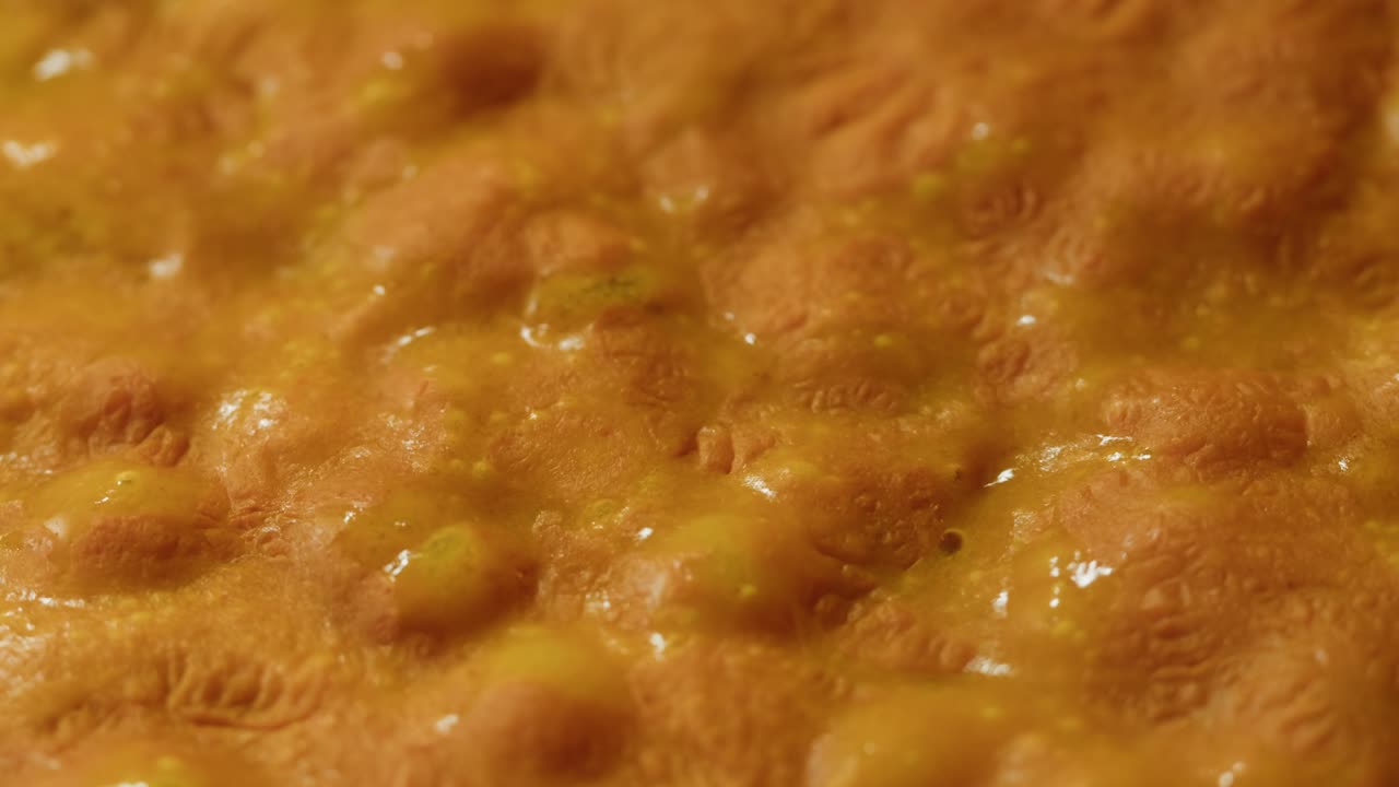 Yellow boiling sauce on pan close-up. Asian cuisine concept. Curry is a dish with a sauce seasoned with spices. Curries may contain fish, meat, poultry, or shellfish, either alone or in combination with vegetables. Others are vegetarian.