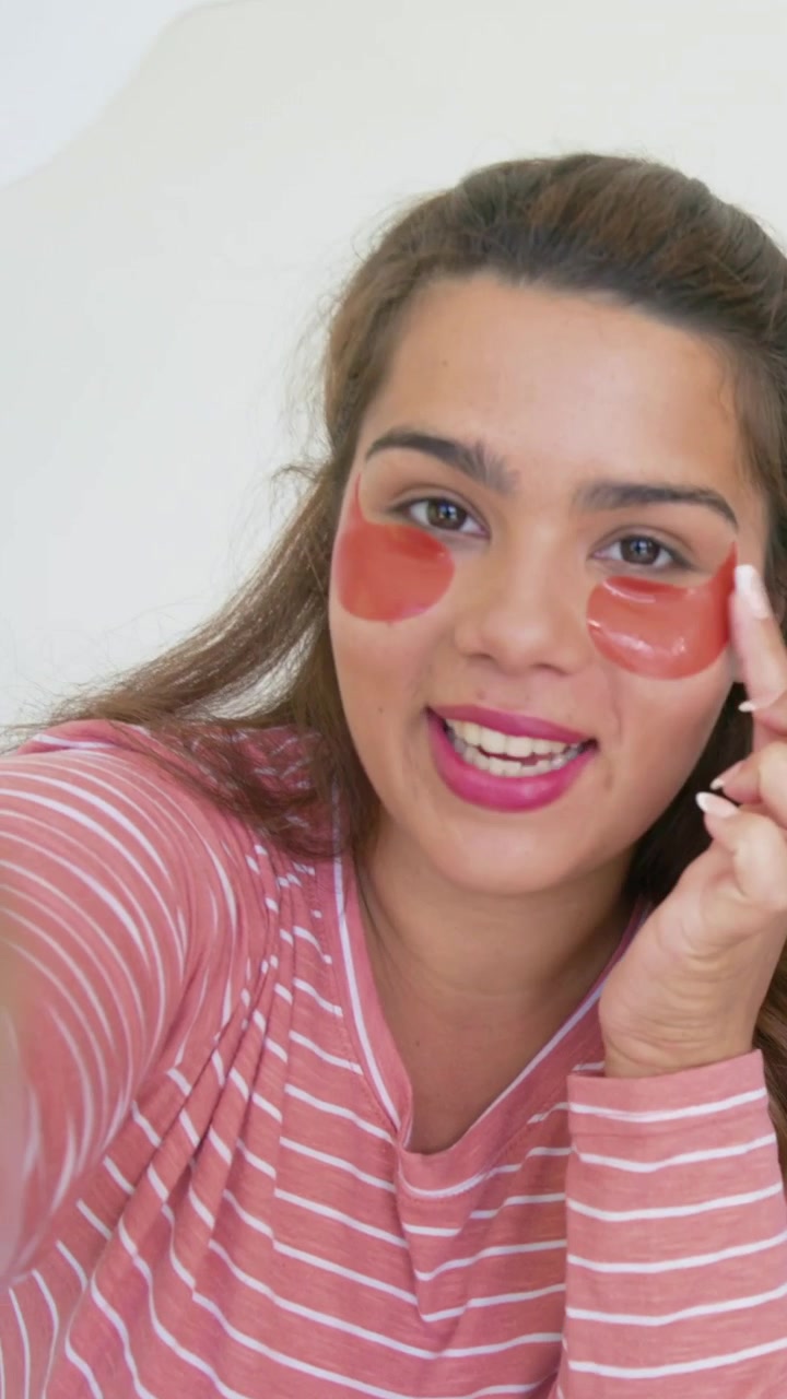 Vertical video: Starting recording woman in pink at home showing and rubbing red patches