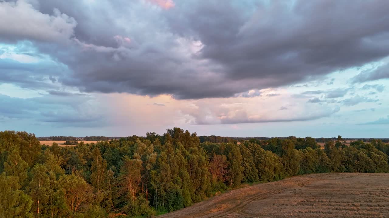 Timelapse of a Grain Field Under Shifting Rain Clouds and a Rainbow as a Storm Builds. Rapid Light Changes and Dramatic Skies Create a Powerful and Visually Striking Natural Scene. Dron Follow Storm