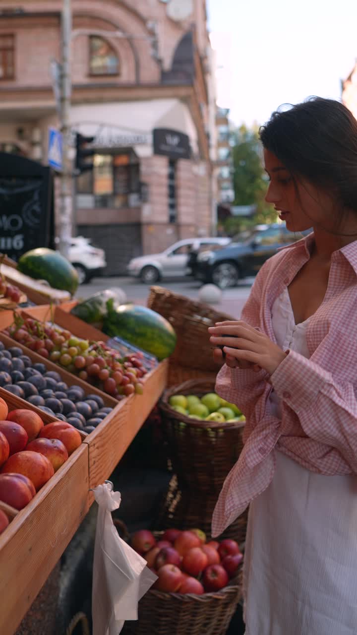 mujer comprando frutas en un mercado al aire libre