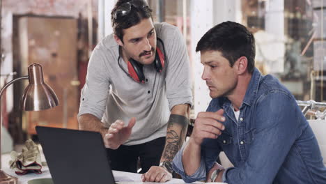 two-young-men-using-a-laptop-in-a-welding-workshop