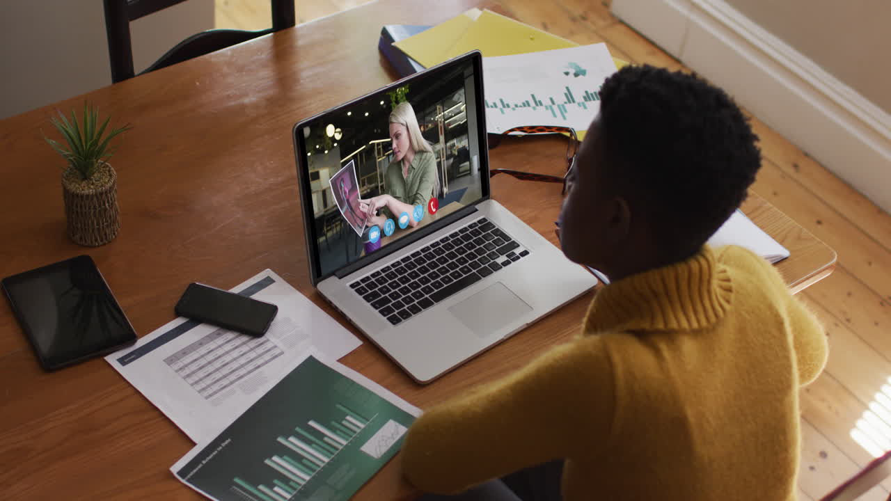 African american woman using laptop on video call with female colleague working from home