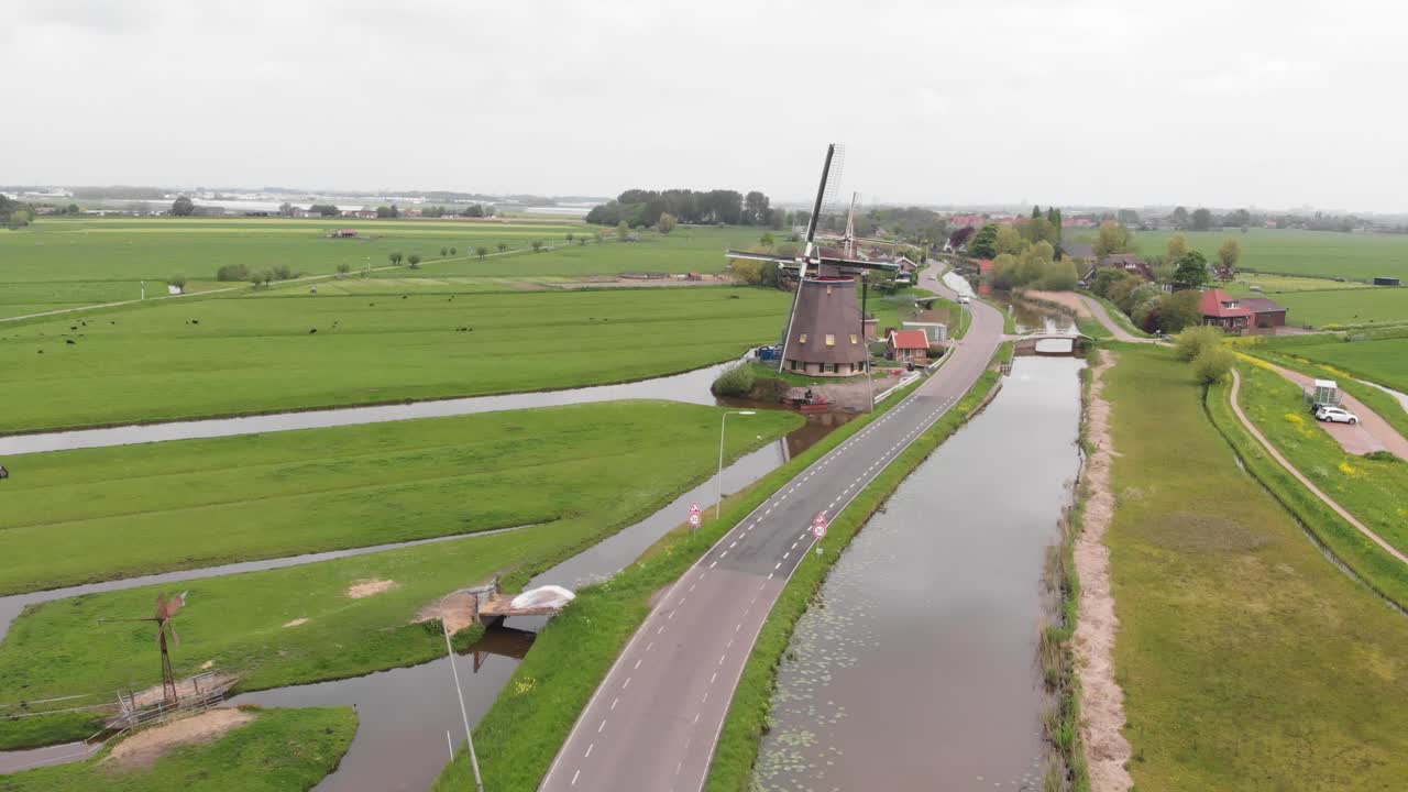 A long drone shot of a rotating windmill in the Netherlands.