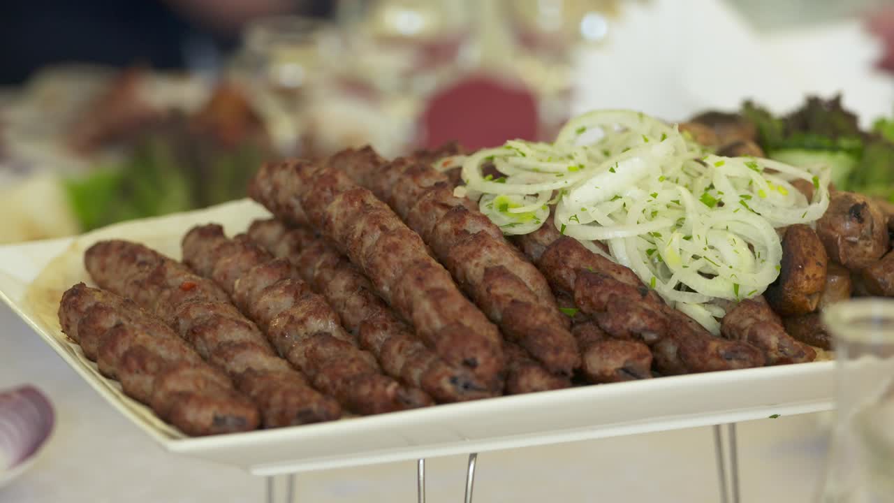 Mesa de cena servida con kebabs de lula y verduras frescas