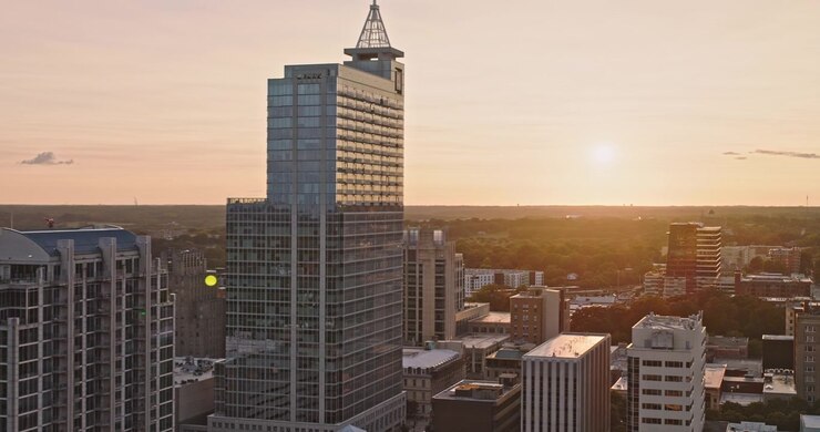 Raleigh, Carolina do Norte, sobrevoo aéreo v27 de baixa altitude passando por torres do centro e o horizonte iluminado durante um pôr do sol quente - Filmado com Câmera 8k - 30 de setembro de 2023