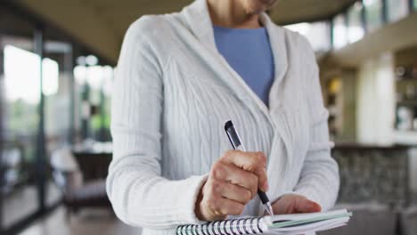 mujer de raza mixta senior tomando notas