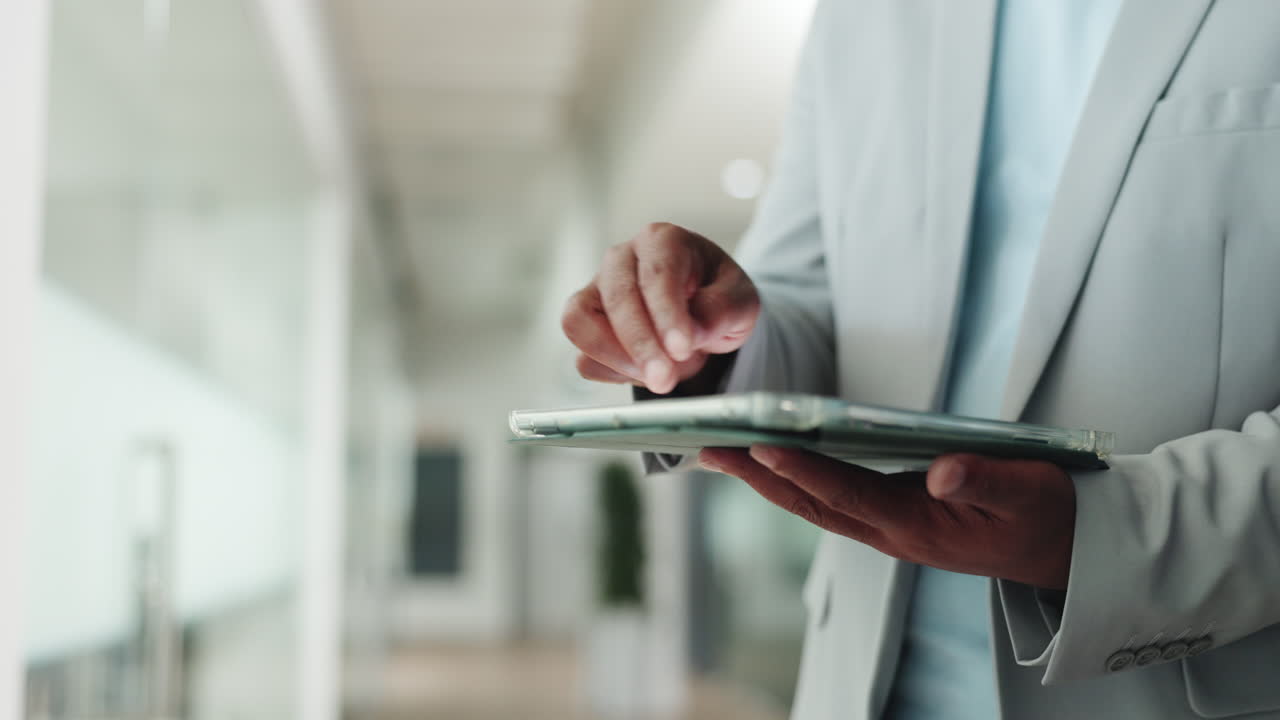 Nærbillede af en professionel person, der bruger en digital tablet på et kontor.