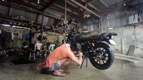 hand washing a motorbike with pressure hose - timelapse filmed in the philippines