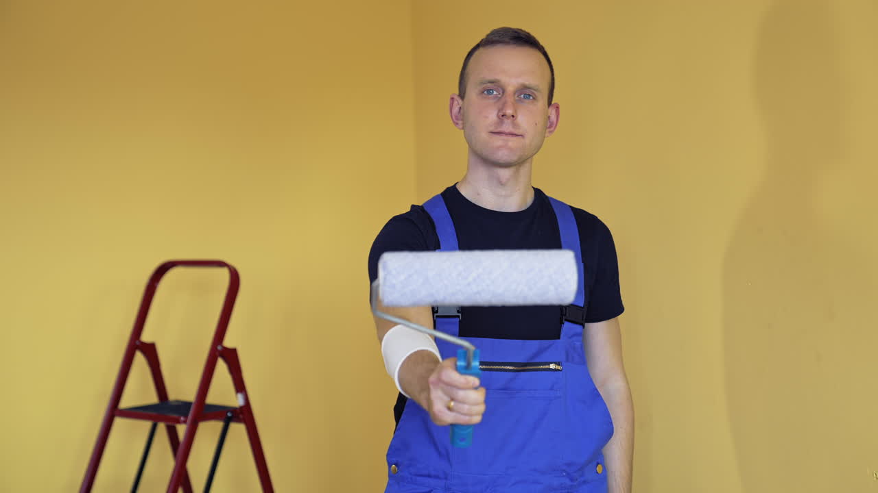 Young professional painter get ready for work. Handsome man doing apartment renovation.