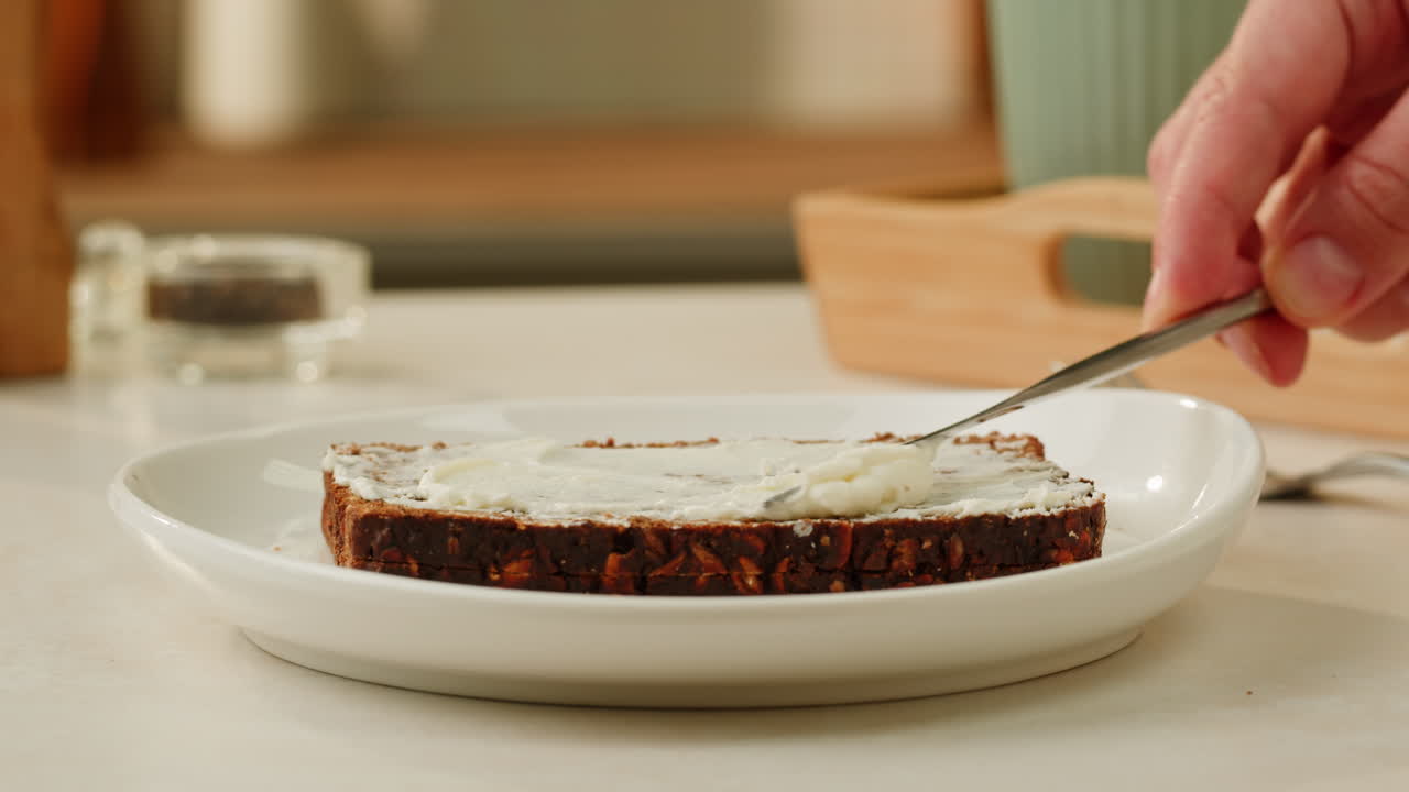 Preparing a slice of bread with cream cheese