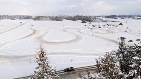 panoramic drone shot of cars racing on a ice track, sunny, winter evening