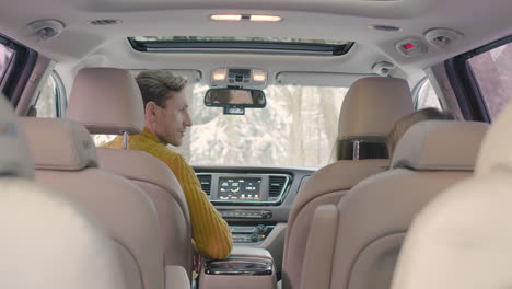 rear view of a husband and wife sitting in the front seats of a car