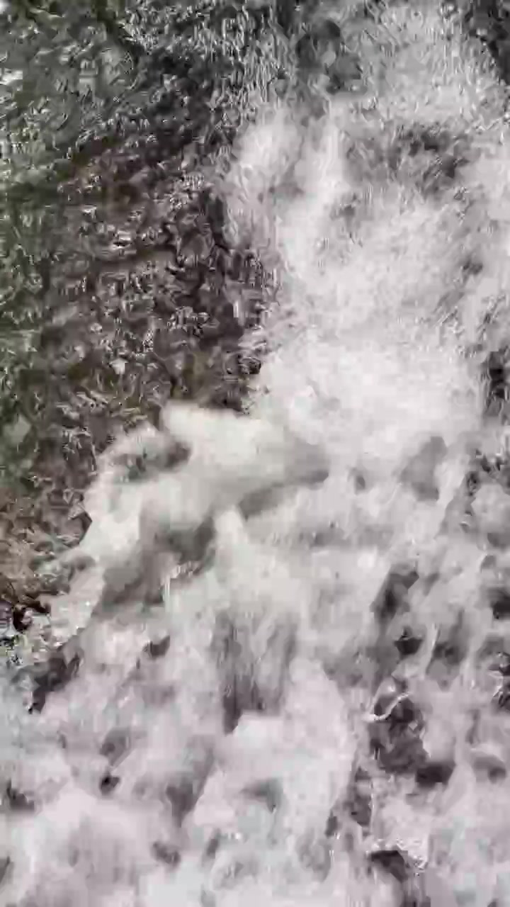 Primo piano di acqua impetuosa che scorre sulle rocce