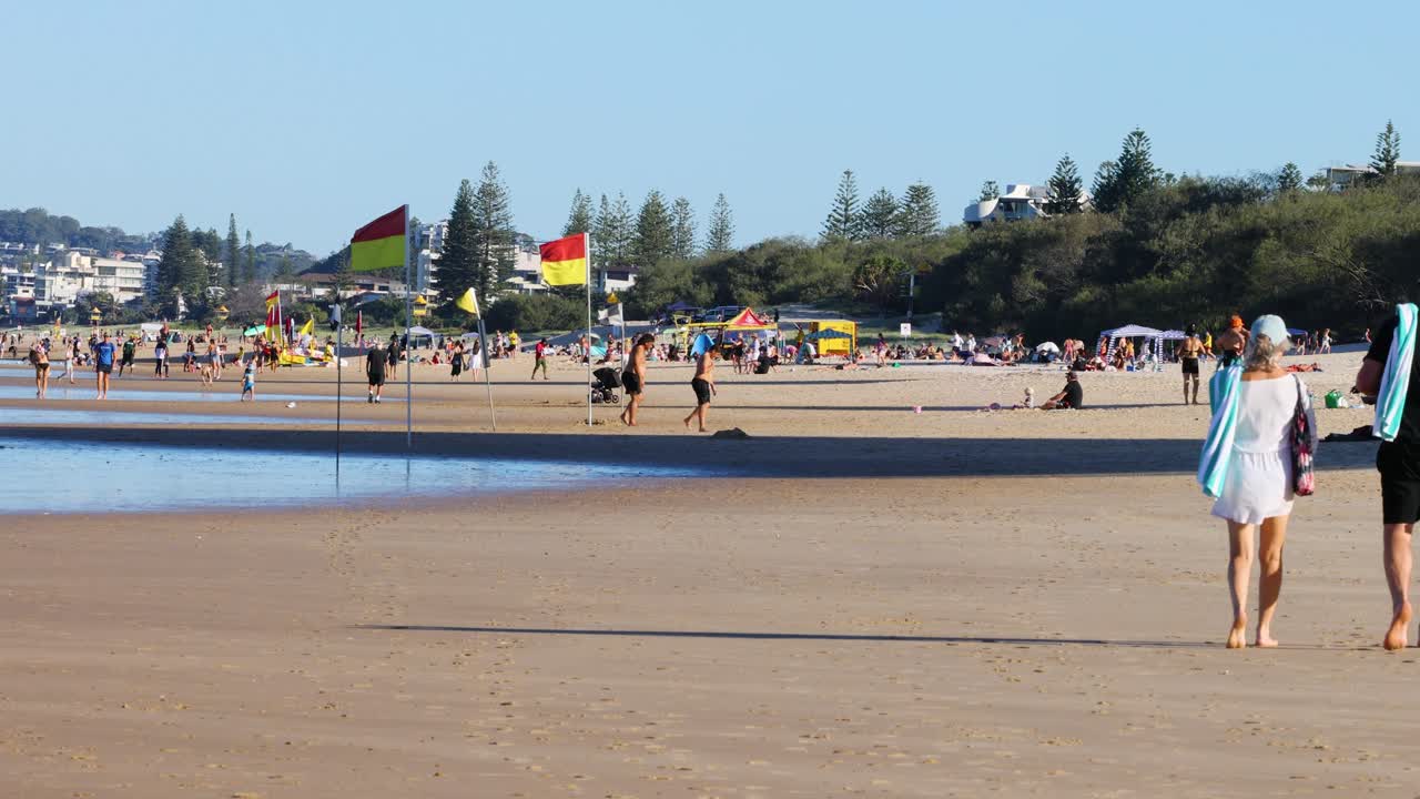 personas disfrutando de un día soleado en la playa