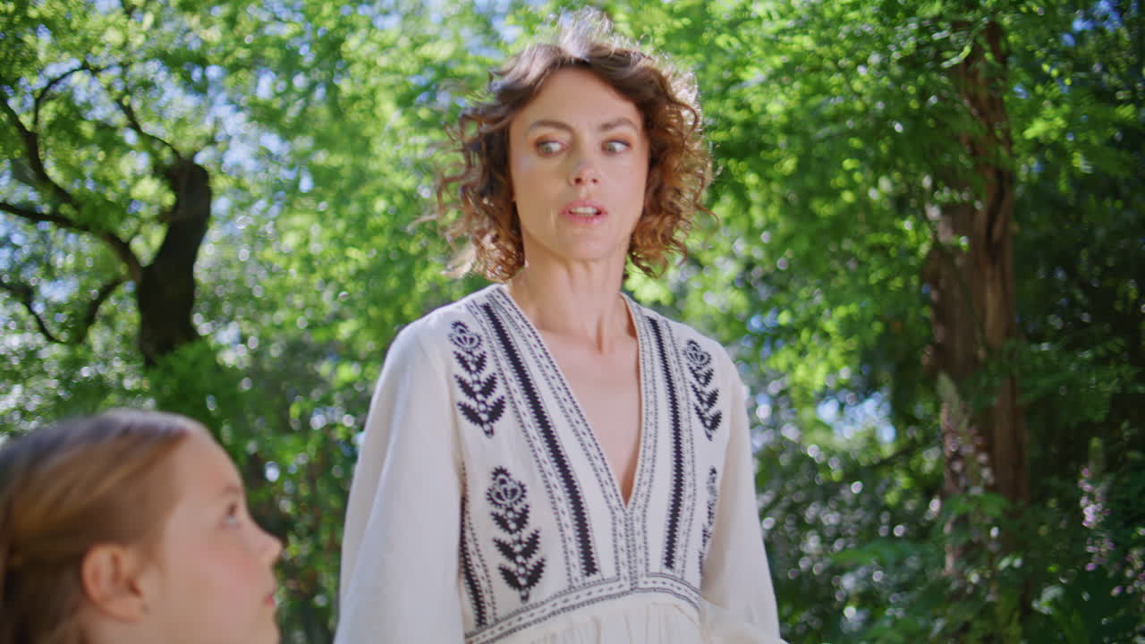 Happy mom child walking at sunshine sprawling park. Carefree family