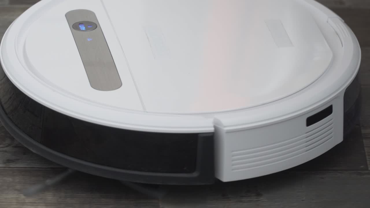el robot aspirador automático se mueve a lo largo de su trayectoria. robot aspirador limpieza automática en el hogar. casa inteligente. moderno aspirador robótico limpia el piso. toma de primer plano. tecnologías modernas