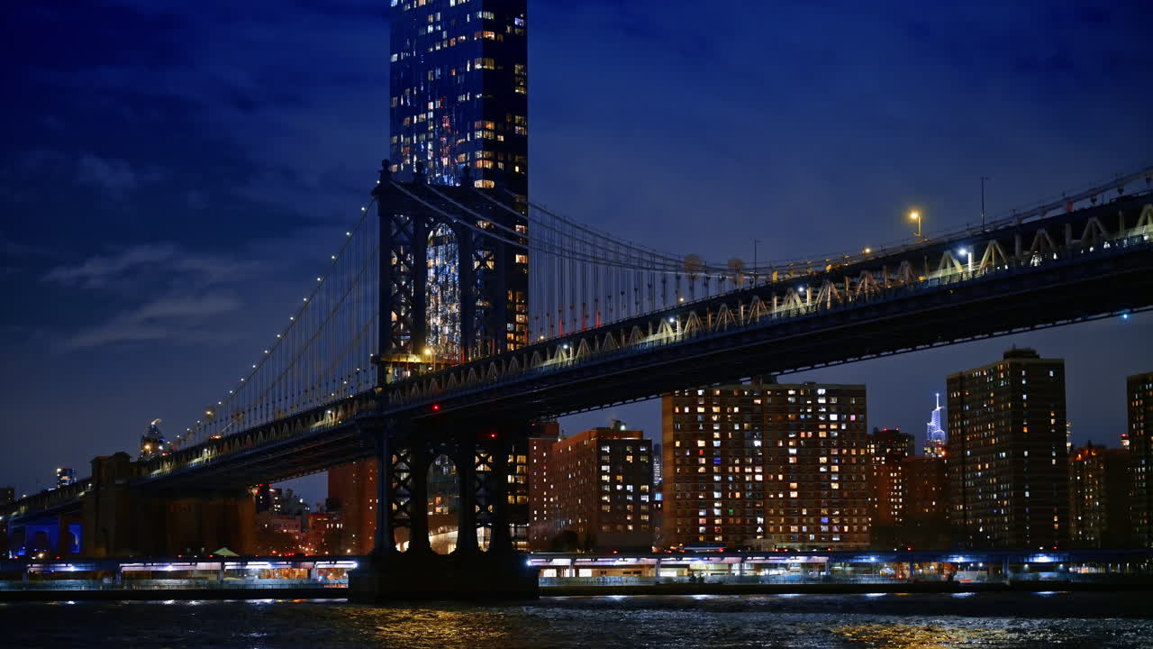 Vista notturna del Ponte di Manhattan e dello skyline di Brooklyn. Lunga esposizione del Ponte di Manhattan sull'East River con edifici e torre della città illuminati.