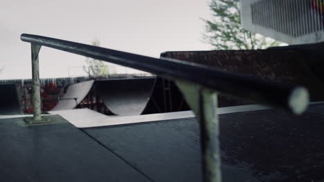 Empty-rail-for-training-on-skate-board-at-skate-park-colorful-graffiti-wall.