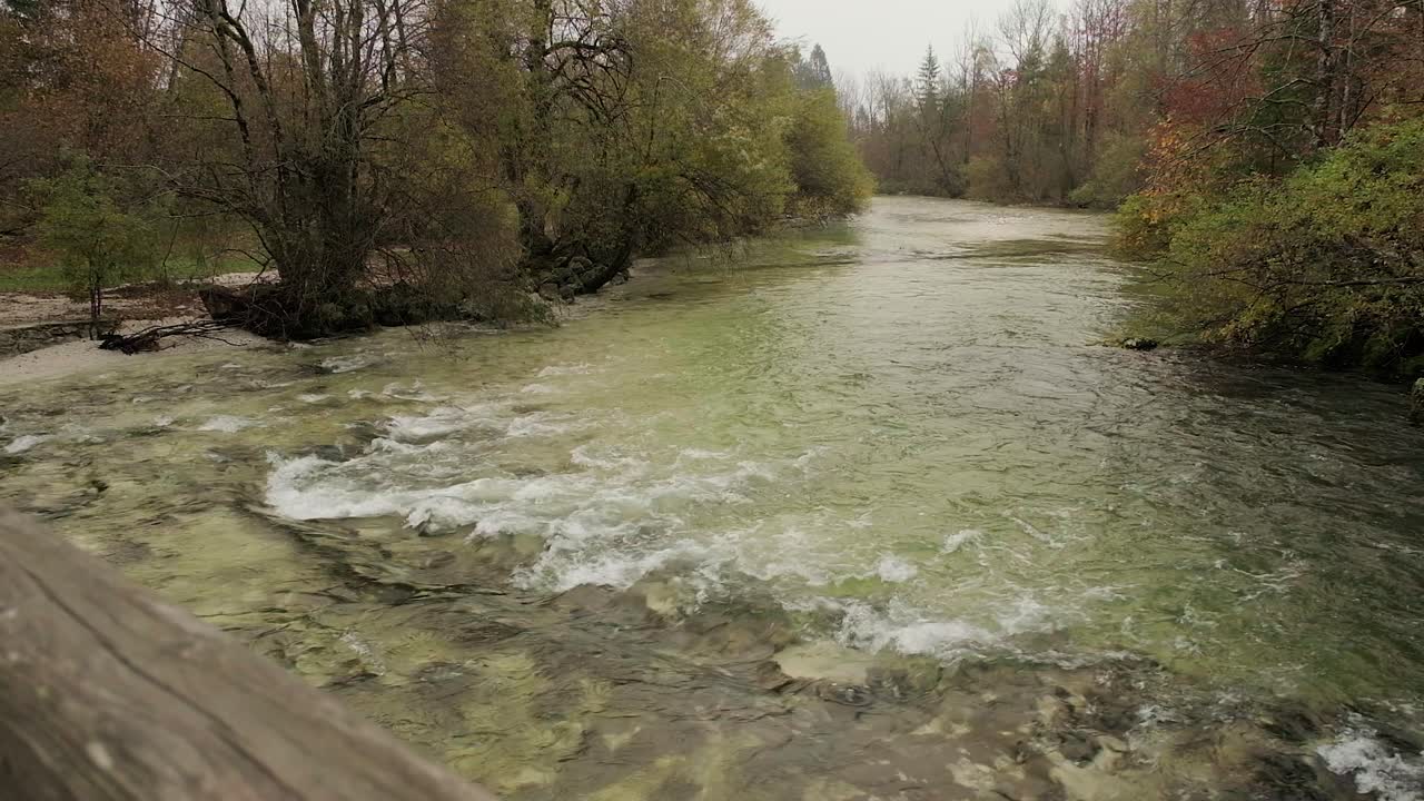 caminar sobre un puente con una pequeña cascada debajo mientras el río de bohinj corre debajo con impresionantes aguas alpinas