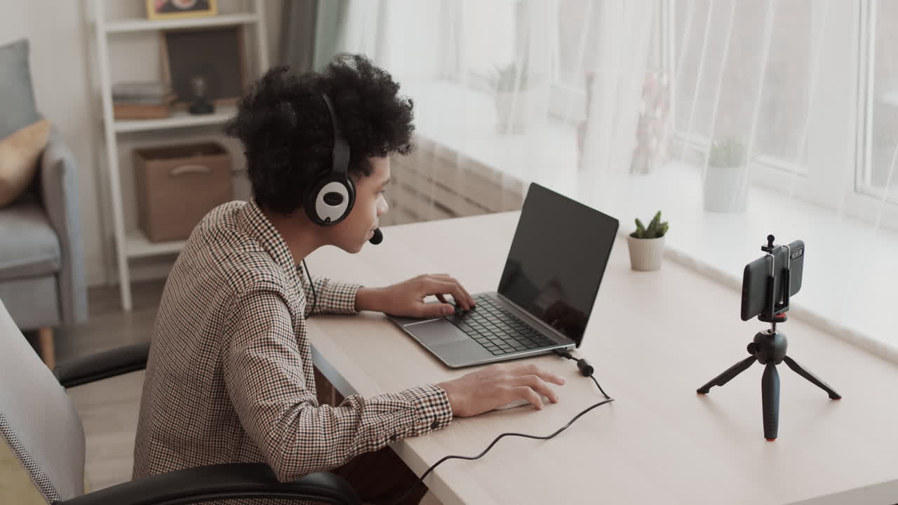 Teenager, der spiller computerspil på bærbar