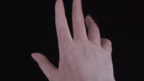 young female hand painted with white color moving smoothly in a black background