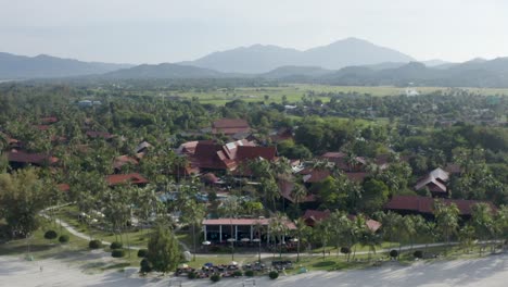 Total-view-tracking-shot-coastline-Langkawi,-beach,-coast,-trees-and-buildings,-no-people,-sunny-day,-daylight