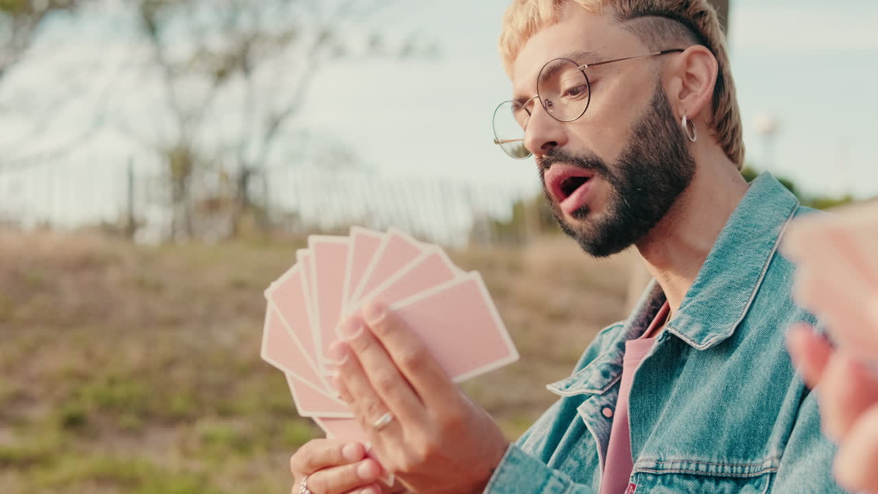 Friends Playing Cards at a Summer Picnic, focus on the young man