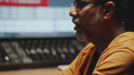 sound engineer adjusting audio controls as recording music in studio