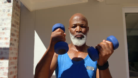 Front-view-of-determined-mature-black-man-exercising-and-looking-at-camera-in-backyard-of-home-4k