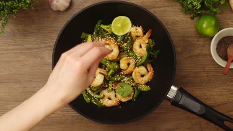 unrecognizable lady serving appetizing dish with shrimps with sesame seeds