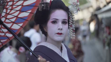 A close-up headshot of a Geisha looking directly at the camera in Kyoto, Japan