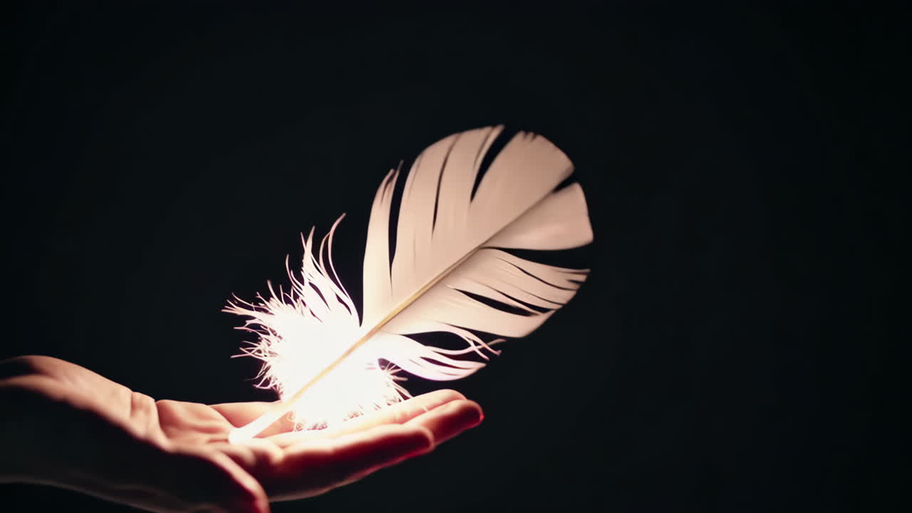 A glowing feather held in a hand