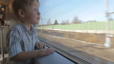 niño agitando la mano por la ventana del tren