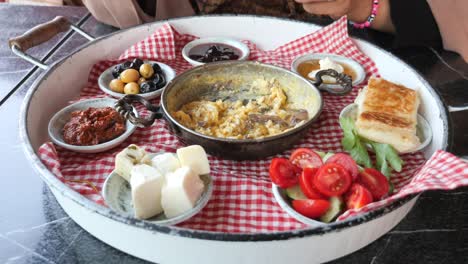 turkish breakfast with scrambled eggs, cheese, olives, and bread