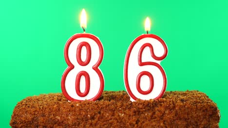 cake with the number 86 lighted candle. chroma key. green screen. isolated