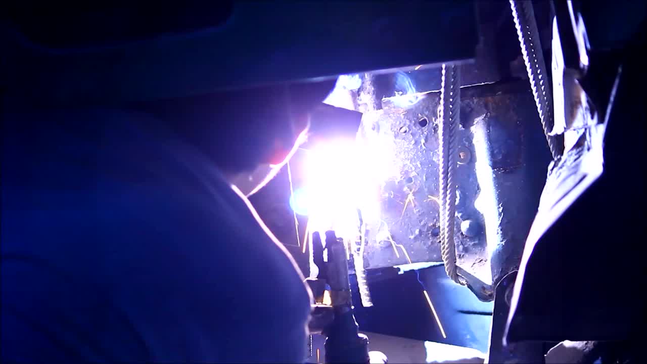 Close up video shot of a worker welding steel together
