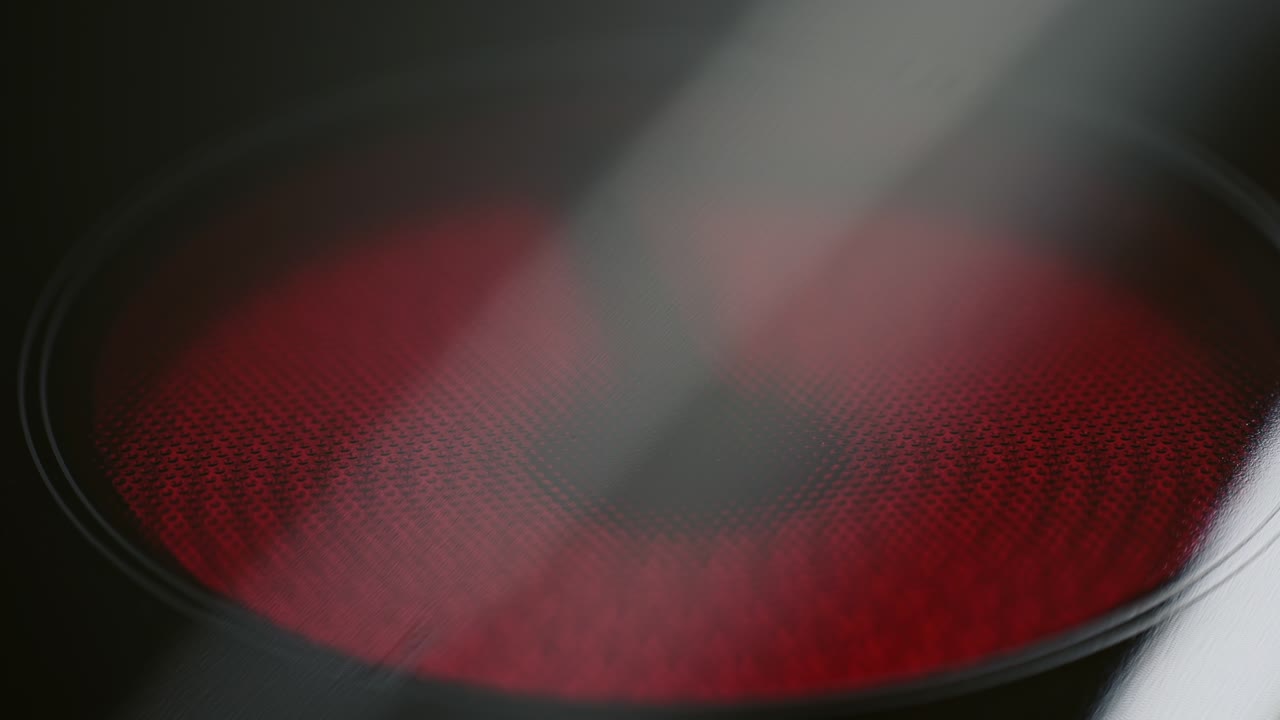 Focusing in a hot glowing red plate or element on a glass-top hob in a kitchen ready fro cooking the dinner in a close up view